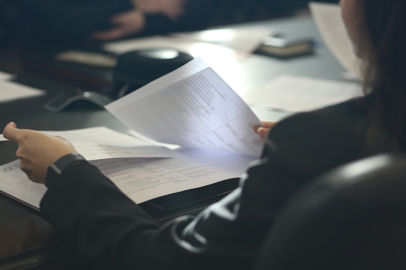 Someone reading a printed document at a desk