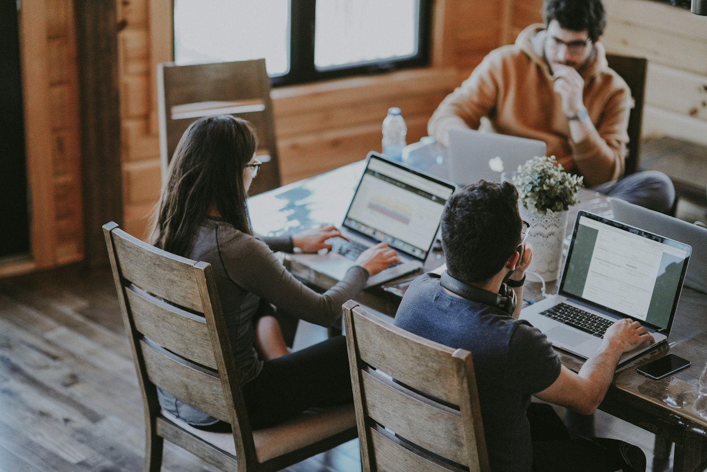 A team working at laptops around a shared desk